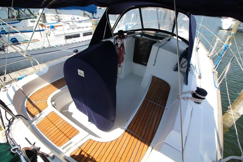 Slide: The Image of 2004 Jeanneau Sun Odyssey 35 sailboat cockpit with wooden seating and covered helm. - 13