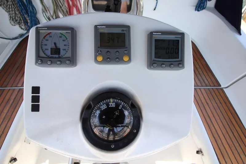 Slide: The Image of Cockpit instruments of a 2004 Jeanneau Sun Odyssey 35 sailboat, featuring navigation displays and compass. - 15
