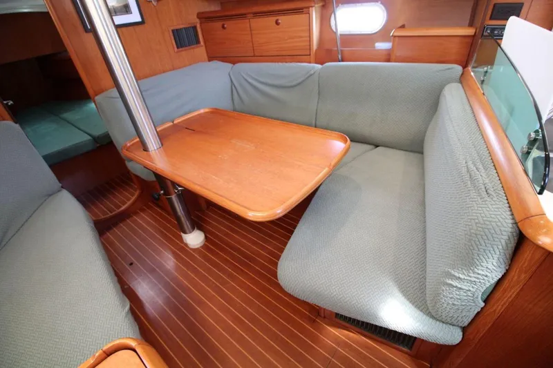 Slide: The Image of Interior of 2004 Jeanneau Sun Odyssey 35 sailboat with cozy seating and wooden table. - 19
