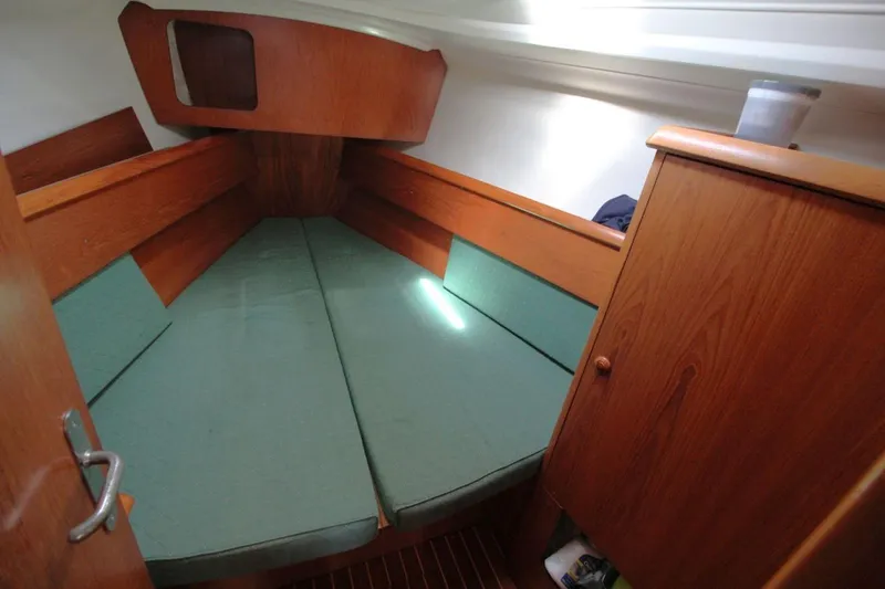 Slide: The Image of Cozy cabin interior of 2004 Jeanneau Sun Odyssey 35 sailboat with green cushions. - 22