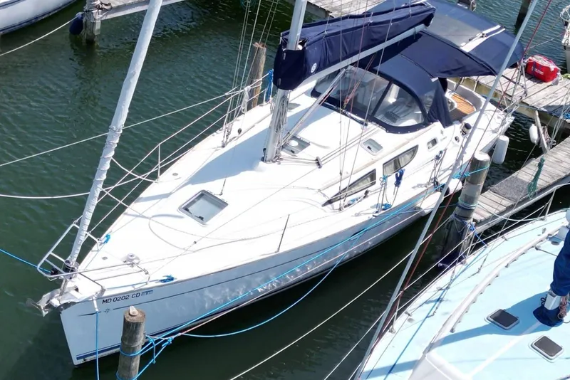 Slide: The Image of 2004 Jeanneau Sun Odyssey 35 sailboat docked in marina, featuring sleek design and blue canopy. - 9