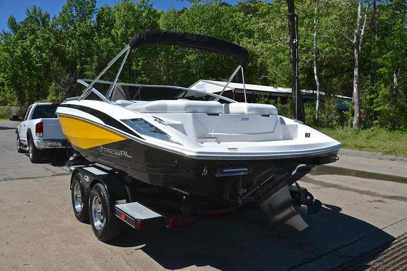 Slide: The Image of 2014 Regal 2100 boat on trailer, featuring sleek design and vibrant yellow accents. - 12