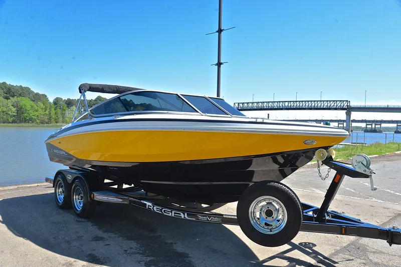 Slide: The Image of 2014 Regal 2100 boat on trailer by a river, sunny day. - 16