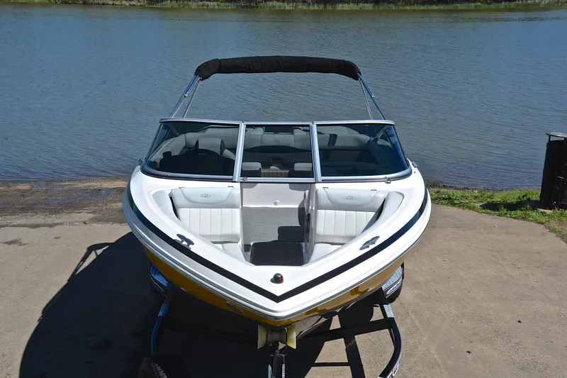 Slide: The Image of 2014 Regal 2100 boat on trailer by a lake. - 17