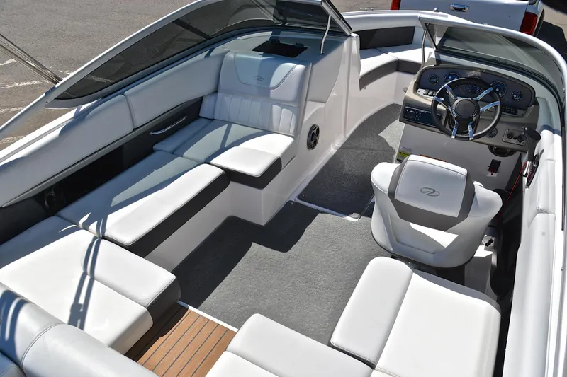 Slide: The Image of 2014 Regal 2100 boat interior with white seating and modern dashboard design. - 19