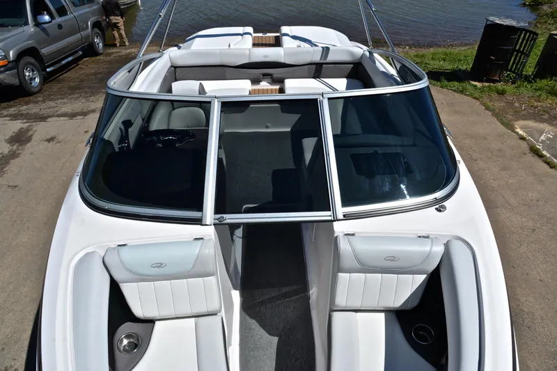 Slide: The Image of 2014 Regal 2100 boat with white interior, docked near a lake. - 20