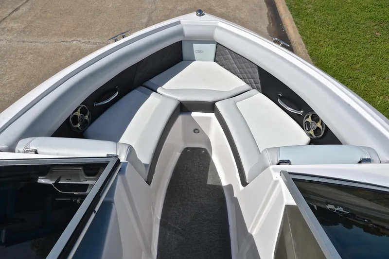 Slide: The Image of 2014 Regal 2100 boat interior with white cushioned seating and sleek design. - 21