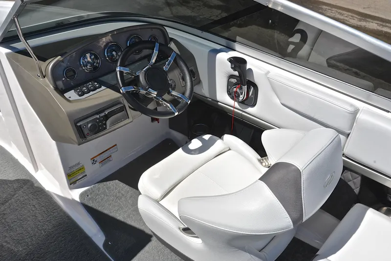 Slide: The Image of Interior of a 2014 Regal 2100 boat featuring a sleek dashboard and comfortable seating. - 24