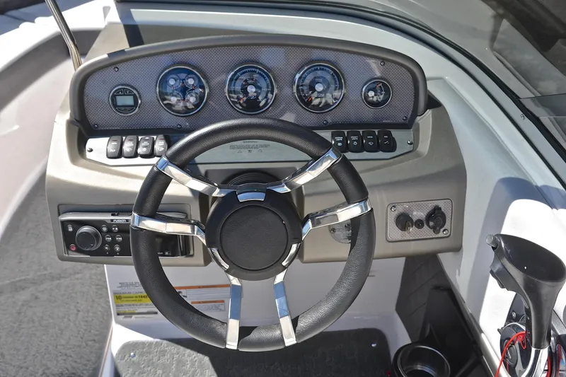 Slide: The Image of Dashboard of a 2014 Regal 2100 boat with steering wheel and gauges. - 25