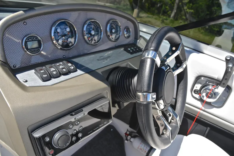 Slide: The Image of Dashboard of a 2014 Regal 2100 boat with steering wheel and control panel. - 26