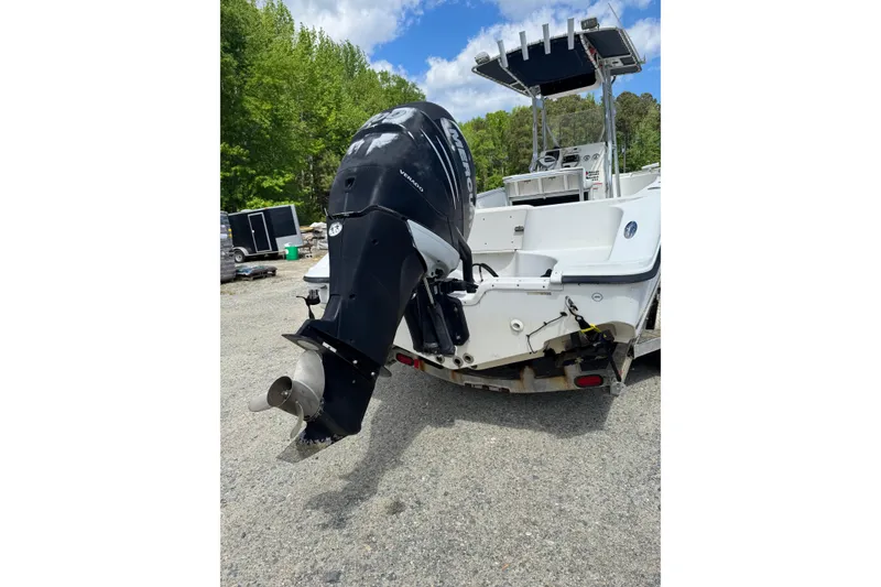 Slide: The Image of 2008 Triton 225 CC boat with Mercury outboard motor, parked outdoors. - 10