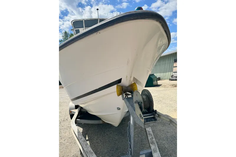 Slide: The Image of 2008 Triton 225 CC boat on trailer, viewed from front, under a partly cloudy sky. - 3