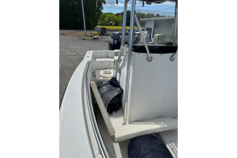Slide: The Image of 2008 Triton 225 CC boat interior with seating and console, parked outdoors. - 7