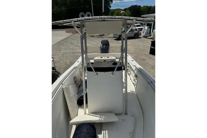 Slide: The Image of 2008 Triton 225 CC boat interior with center console and T-top in a parking area. - 8