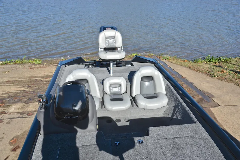 Slide: The Image of 2018 Bass Tracker Pro 19 boat with seating, near a lake shore. - 23