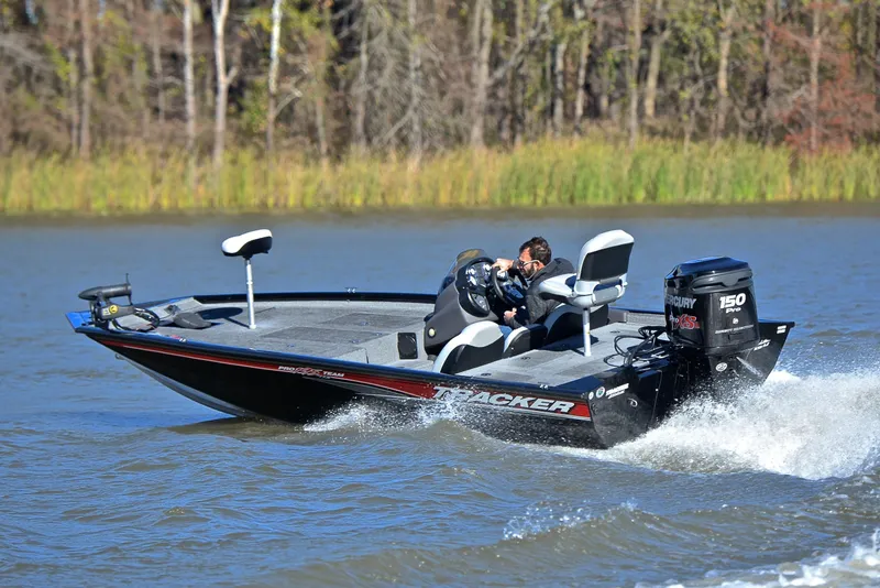 Slide: The Image of 2018 Bass Tracker Pro 19 boat speeding on a lake with lush greenery in the background. - 6