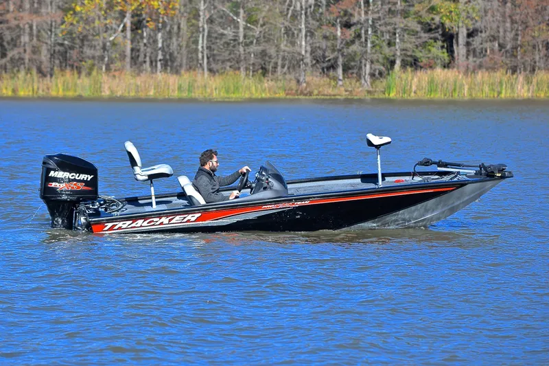 Slide: The Image of 2018 Bass Tracker Pro 19 boat on a lake with a person driving. - 7