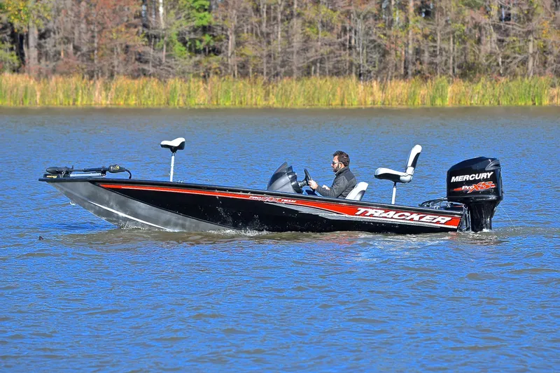 Slide: The Image of 2018 Bass Tracker Pro 19 boat cruising on a lake with a Mercury engine. - 9