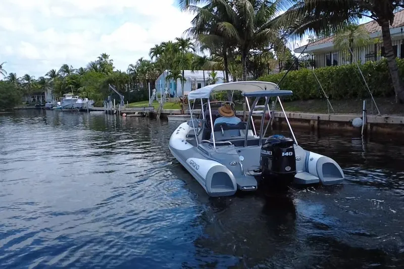 Slide: The Image of 2020 Grand Inflatables G580 boat cruising on a scenic waterway with palm trees. - 14