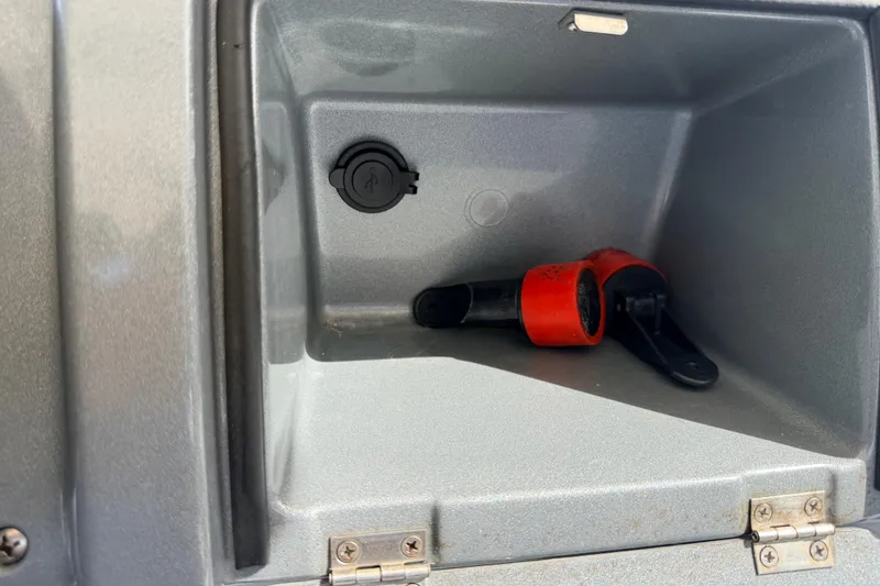 Slide: The Image of Storage compartment of 2020 Grand Inflatables G580 with a red and black tool inside. - 28