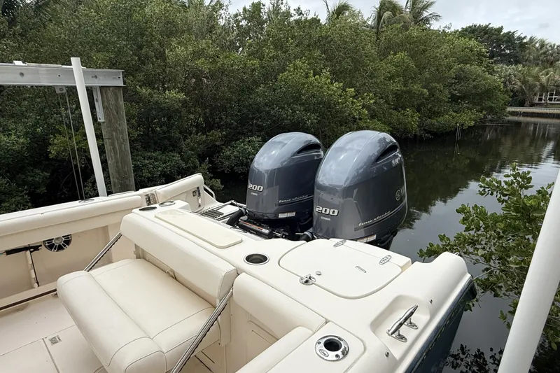 Slide: The Image of 2021 Grady-White Freedom 255 boat with twin Yamaha 200 engines in a lush, green setting. - 3