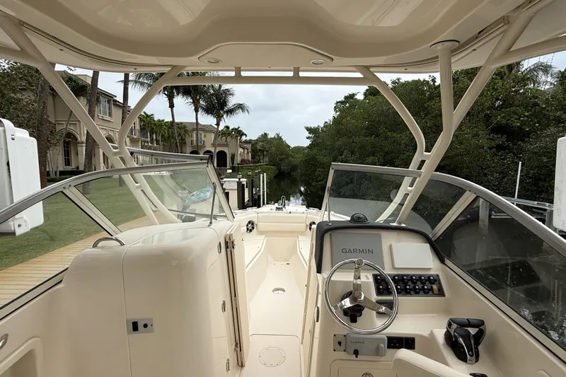 Slide: The Image of 2021 Grady-White Freedom 255 boat interior with Garmin navigation, docked near luxury homes. - 5