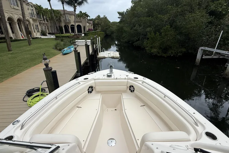 Slide: The Image of 2021 Grady-White Freedom 255 boat docked by a lush canal. - 6