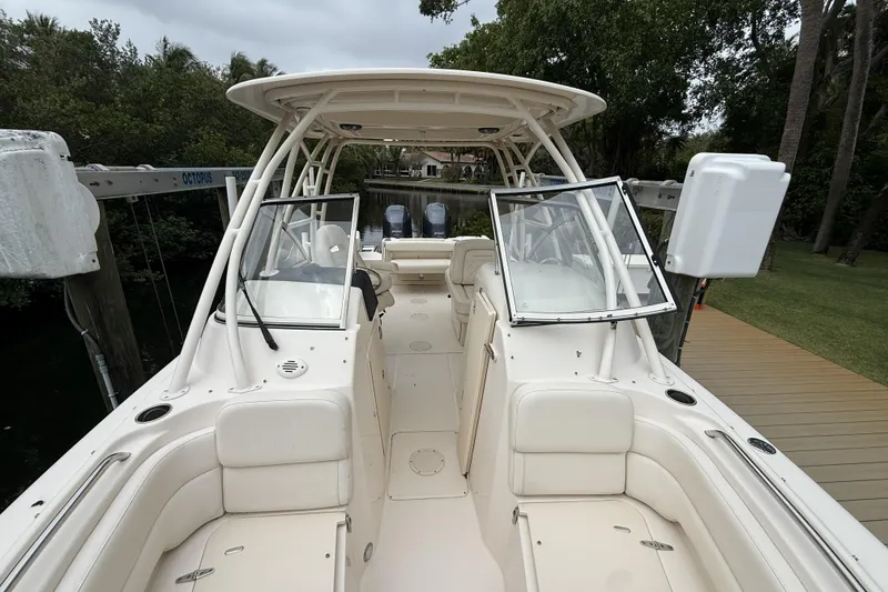 Slide: The Image of 2021 Grady-White Freedom 255 boat with open cockpit and dual consoles, docked near lush greenery. - 7