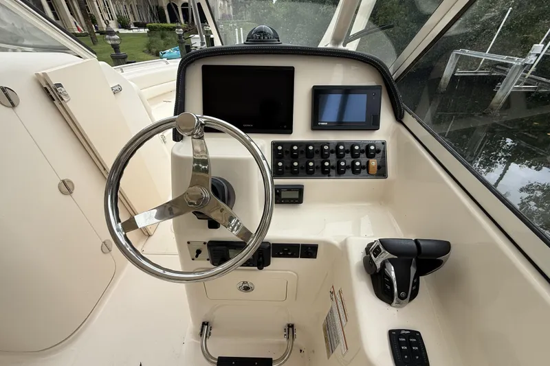 Slide: The Image of Helm of 2021 Grady-White Freedom 255 boat with steering wheel and control panel. - 8