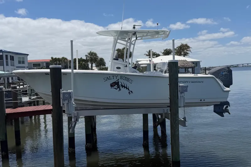 The Image of 2015 Sportsman Heritage 231 Center Console boat docked by waterfront homes. - 0