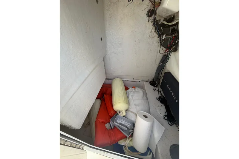 Slide: The Image of Storage compartment of a 2015 Sportsman Heritage 231 Center Console boat with equipment and supplies. - 13