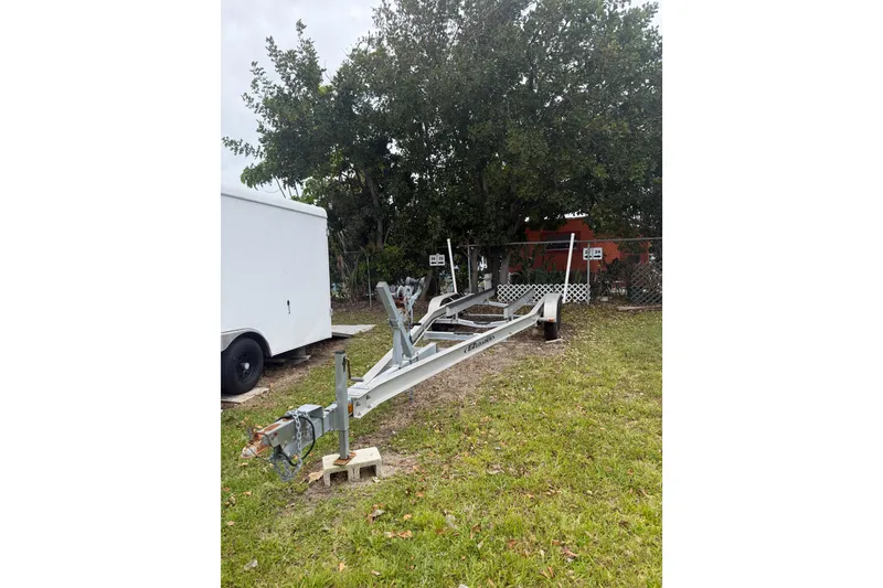 Slide: The Image of Trailer for 2015 Sportsman Heritage 231 Center Console, parked on grass near trees. - 15