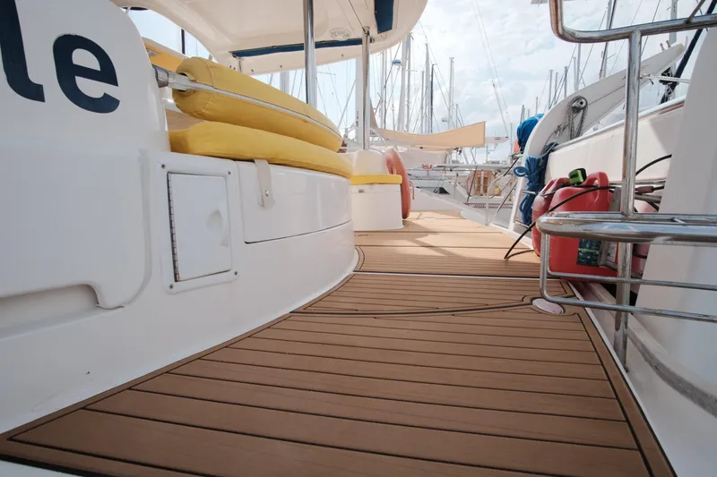 Slide: The Image of Deck view of a 2007 Leopard 46 yacht with yellow seating and wooden flooring. - 32