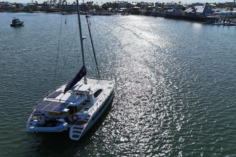 Slide: The Image of Sailing catamaran Leopard 46 (2007) on sunlit water near coastal town. - 4