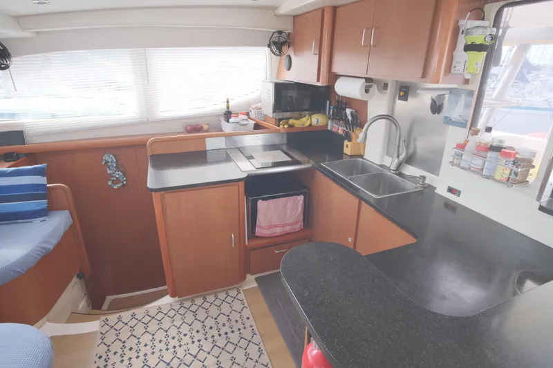 Slide: The Image of Modern kitchen interior of 2007 Leopard 46 yacht with wooden cabinets and black countertops. - 44