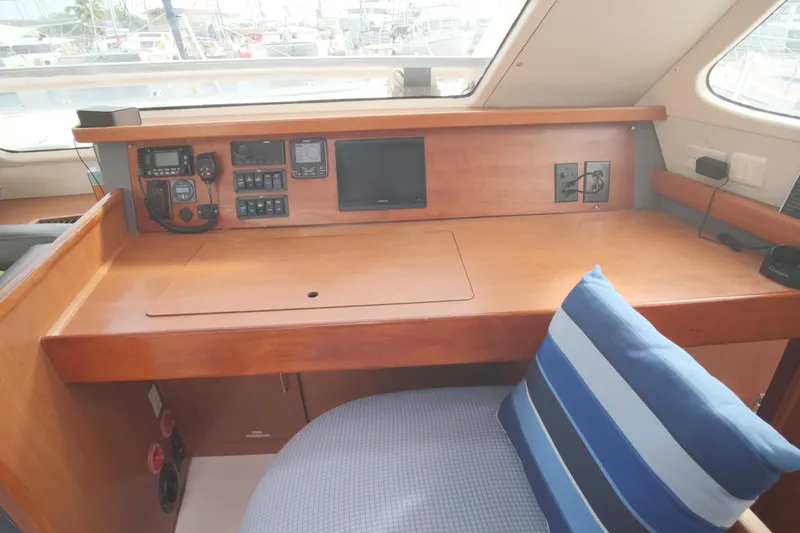 Slide: The Image of Navigation station on a 2007 Leopard 46 yacht with control panels and striped cushion. - 48