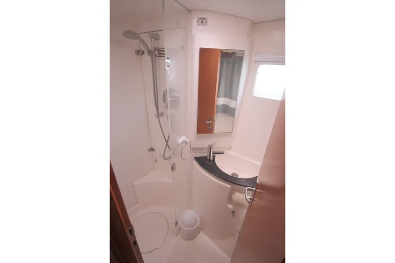 Slide: The Image of Compact bathroom in a 2007 Leopard 46 yacht, featuring a shower, sink, and mirror. - 54