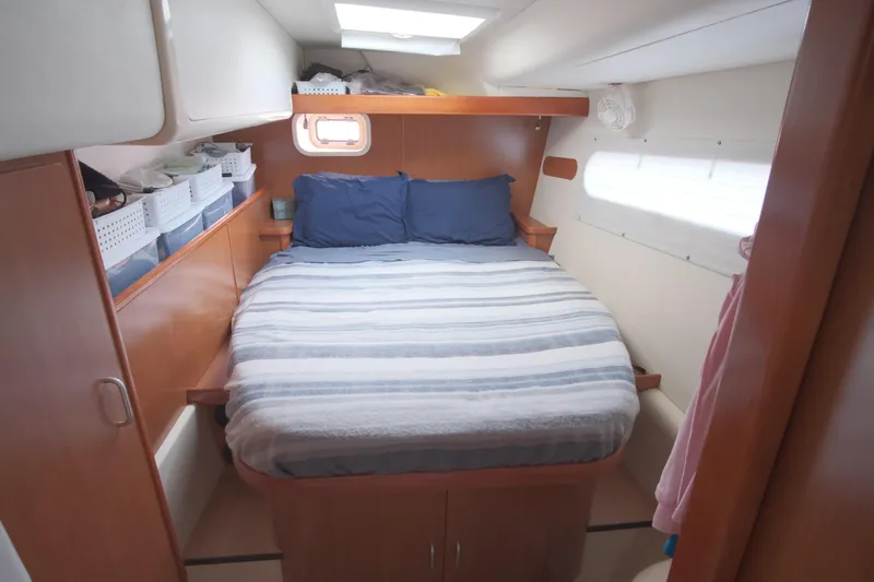 Slide: The Image of Cozy cabin bedroom in a 2007 Leopard 46 yacht with striped bedding and storage baskets. - 56
