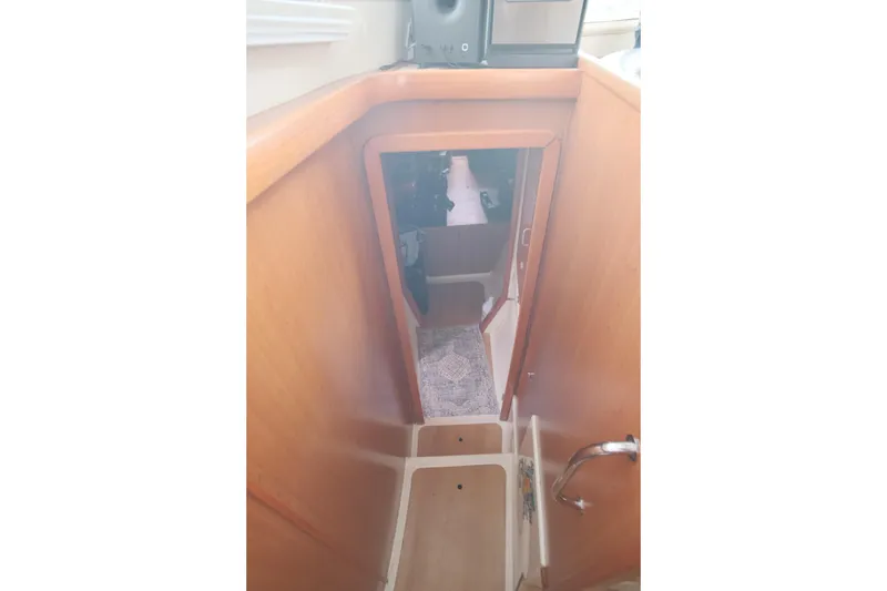 Slide: The Image of Interior view of a 2007 Leopard 46 yacht, featuring wooden stairs and a cozy cabin. - 57