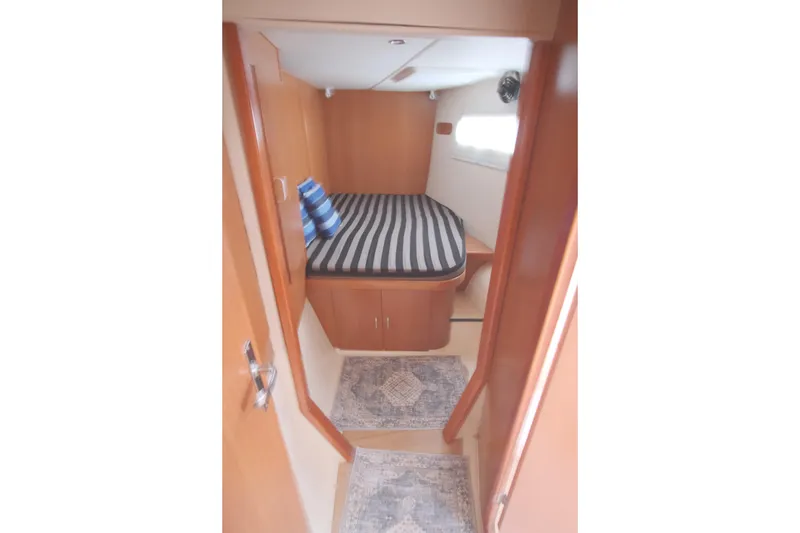 Slide: The Image of Cozy cabin interior of 2007 Leopard 46 yacht with striped bedding and wooden finish. - 61