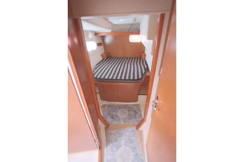 Slide: The Image of Cozy cabin interior of 2007 Leopard 46 yacht with striped bedding and wooden finish. - 62