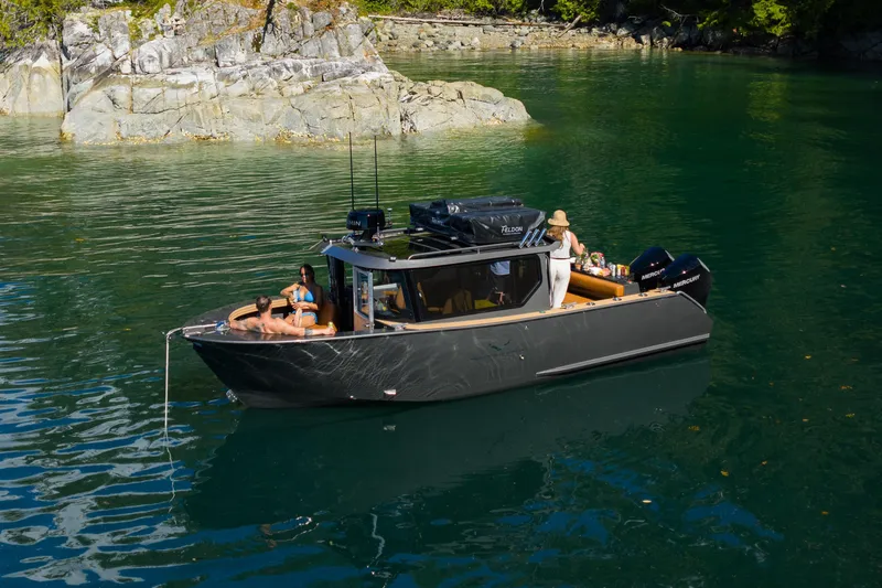 Slide: The Image of 2026 Jasper Marine Defender 22 boat on serene water with passengers relaxing. - 7