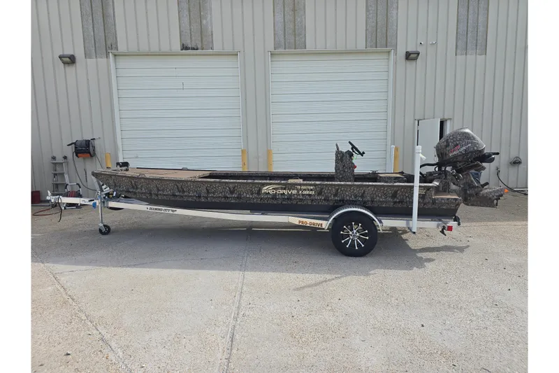 The Image of 2026 Pro-Drive 2060 boat on trailer, parked outside industrial building. - 0