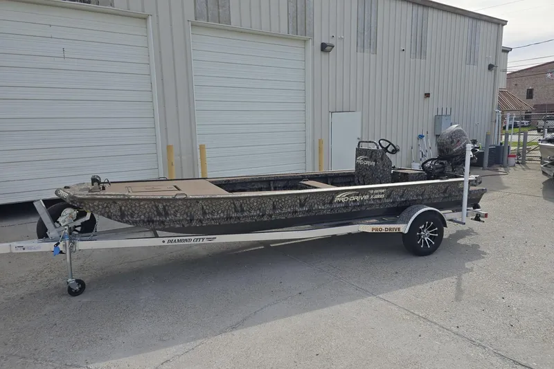 Slide: The Image of 2026 Pro-Drive 2060 boat on trailer, parked outside industrial building. - 3