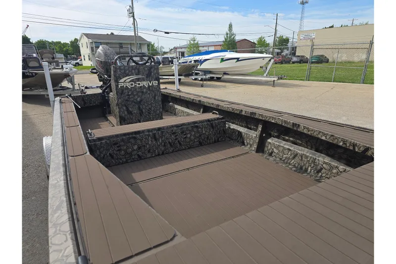 Slide: The Image of 2026 Pro-Drive 2060 boat with camouflage interior, parked outdoors on a sunny day. - 5