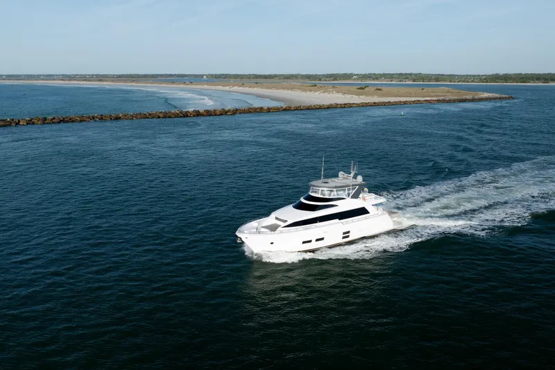 Slide: The Image of 2017 Hatteras M75 Panacera yacht cruising near a scenic coastline. - 10
