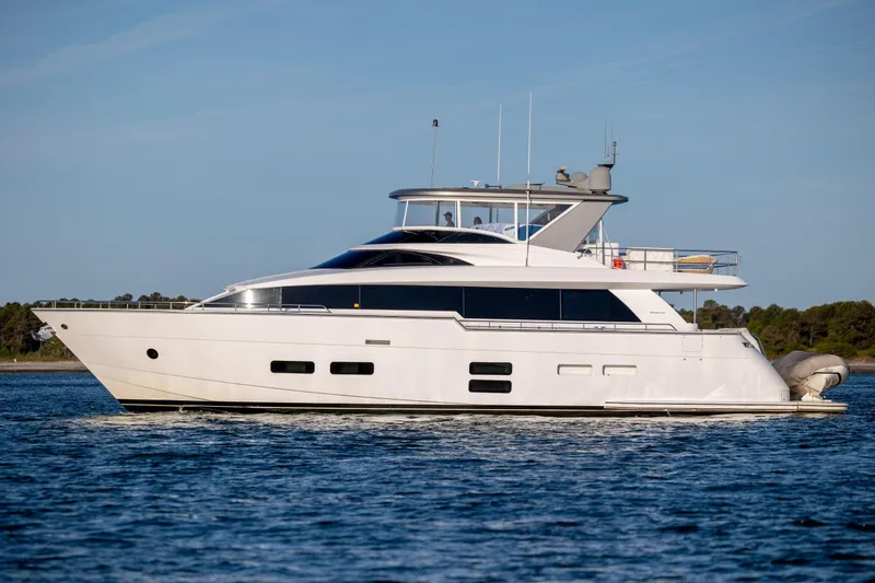 Slide: The Image of 2017 Hatteras M75 Panacera yacht cruising on calm waters under a clear blue sky. - 12