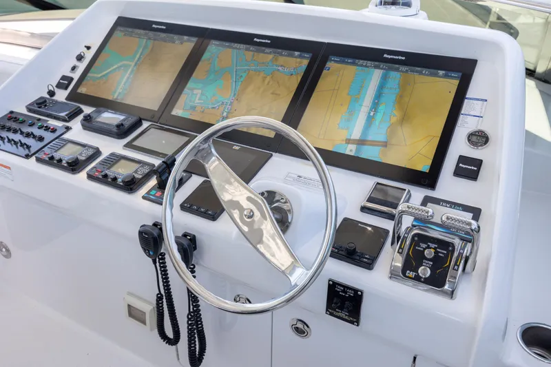 Slide: The Image of Control panel of a 2017 Hatteras M75 Panacera yacht with navigation screens and steering wheel. - 28