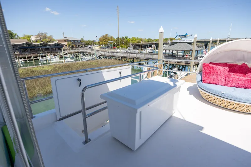 Slide: The Image of Deck view of 2017 Hatteras M75 Panacera yacht with seating and marina backdrop. - 34