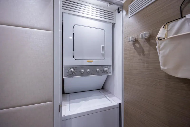 Slide: The Image of Laundry area inside 2017 Hatteras M75 Panacera yacht with stacked washer and dryer. - 72